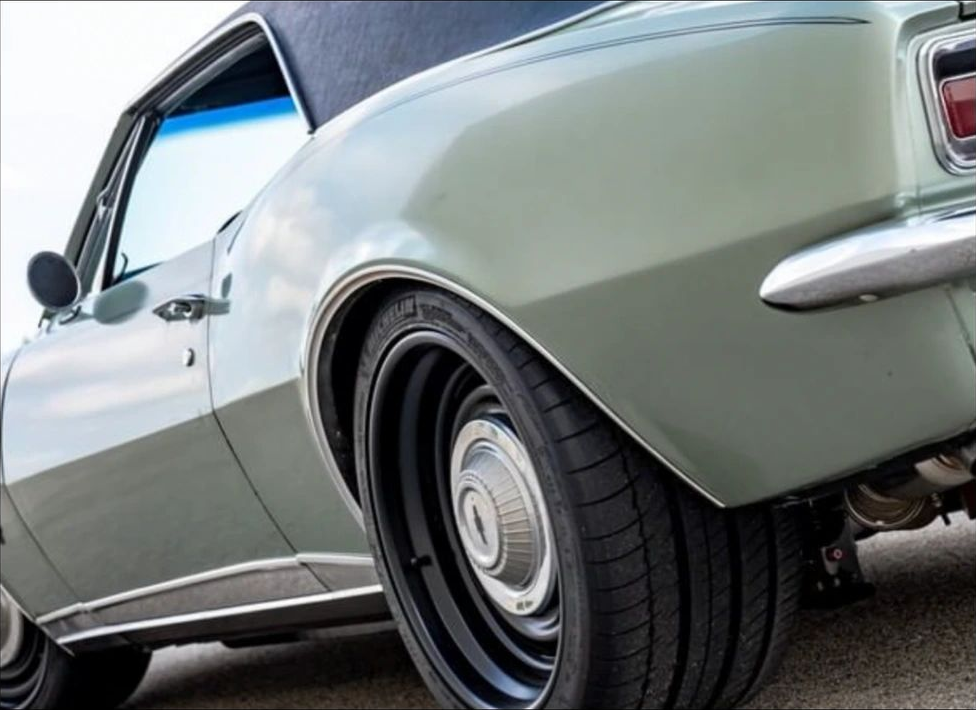 Restored green 1960s hardtop coupe with black vinyl roof, the kind of show-ready car St. Albert owners bring to Rock'n August