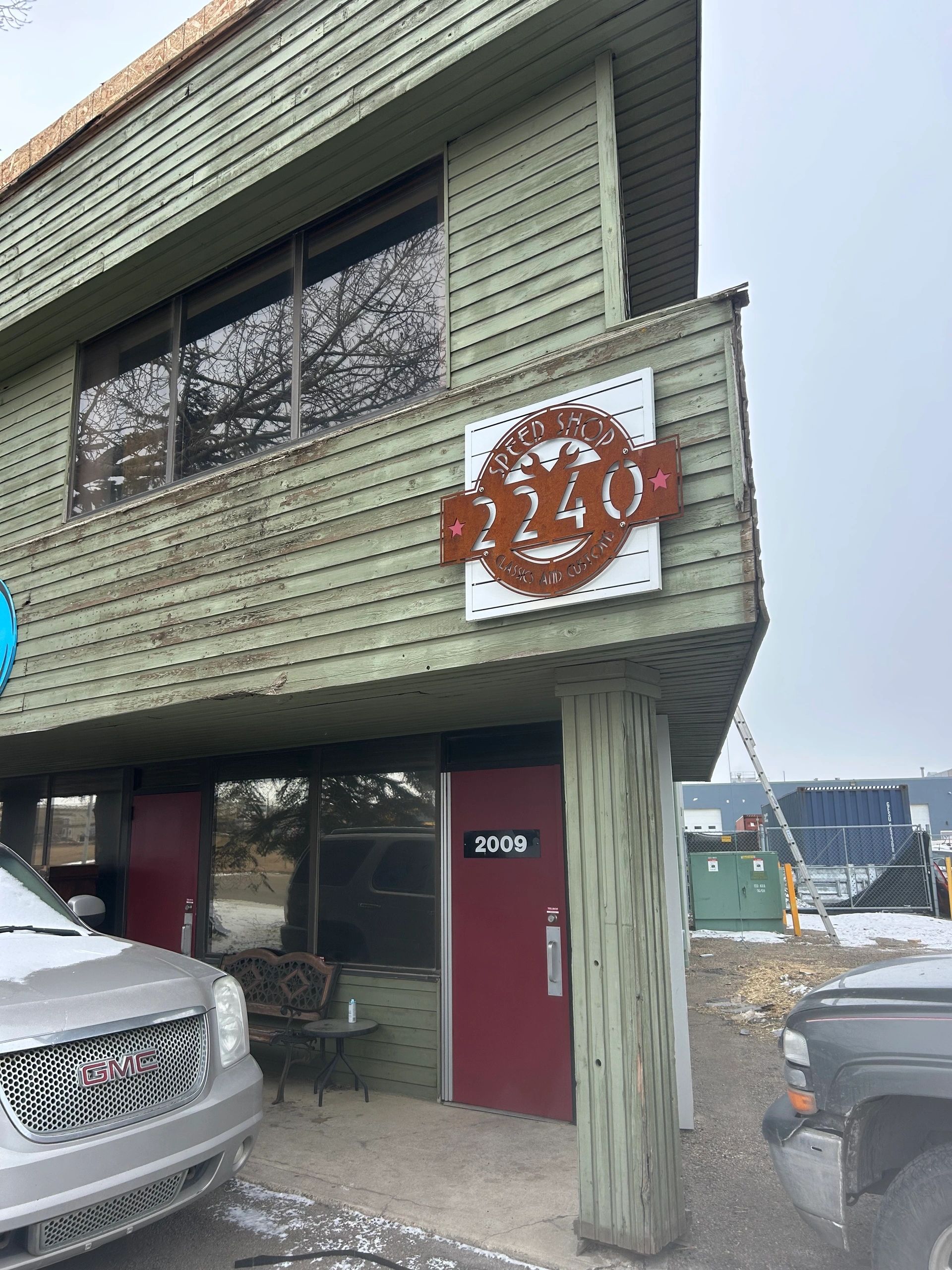 The cut-steel Speed Shop 2240 Classics and Customs sign with crossed wrenches above the door of 2240 Speed Shop in Edmonton