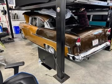 Brown 1955 Chevrolet undergoing work beneath the storage lift at 2240 Speed Shop